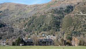 Un paisaje montañoso con un grupo de edificios en primer plano.