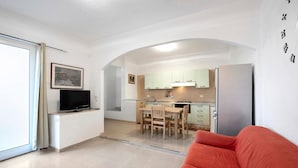 Eine moderne Wohnung mit Küche, Essbereich und Wohnzimmer mit rotem Sofa.