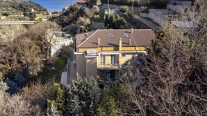Un immeuble résidentiel doté d’un toit en pente, d’un balcon et offrant une vue sur la mer.