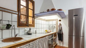 A kitchen with a sink, stove, oven, and a refrigerator.