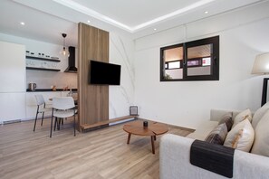 Un salon moderne avec un canapé, une table basse et un téléviseur fixé au mur.
