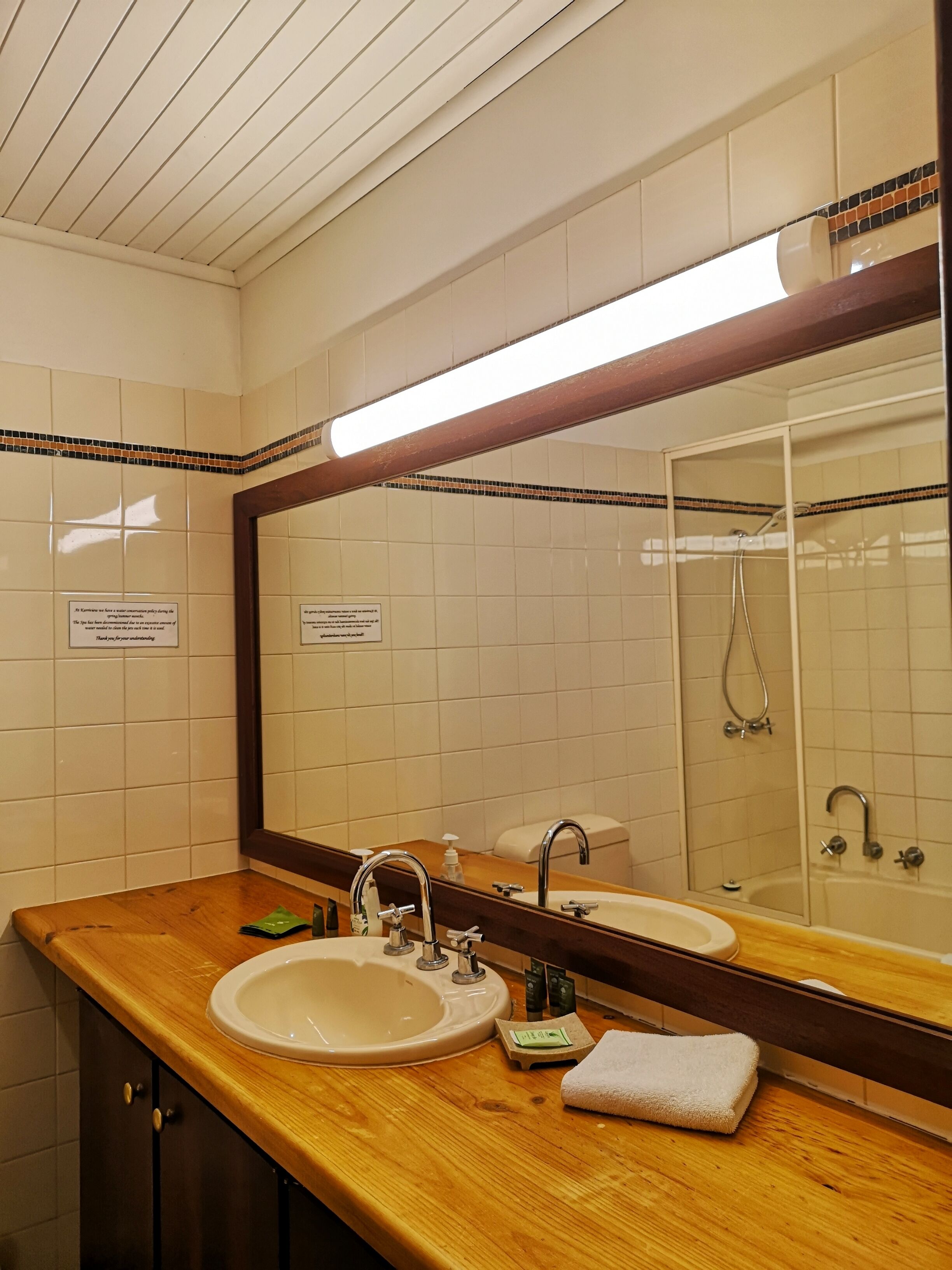 Un bagno con due lavandini, uno specchio grande e una doccia.