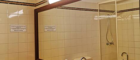 Un bagno con due lavandini, uno specchio grande e una doccia.
