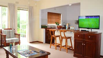 Deluxe Cottage | Living area | 32-inch plasma TV with satellite channels