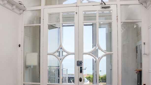 A white double door with glass panels and a fire extinguisher mounted on the right side. - 2 Seaview @ Bridlington Bay (Bridlington)