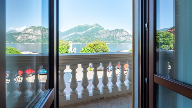 A balcony with a view of mountains and a lake.