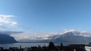 Eine Berglandschaft mit einem See und Gebäuden im Vordergrund.