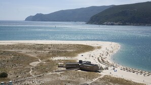 Une zone côtière comprenant une plage, une jetée et un bâtiment doté d’un toit plat.