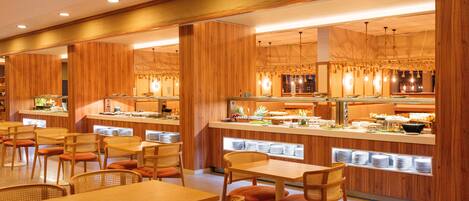 Un restaurante con paneles de madera, mesas, sillas y una zona de bufé.