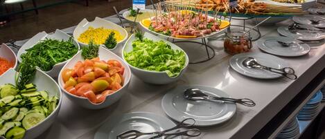 A buffet with various food items and utensils.