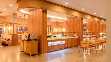 Un moderno vestíbulo de hotel con paneles de madera, un mostrador de recepción y una barra de desayuno.