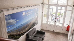 En trappe med en grå sofa, en brandslukker og et billede af Bridlington Bay Apartments.