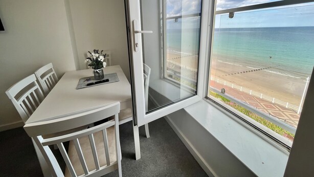 En balkon med udsigt over stranden og havet.