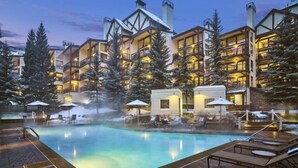 A hotel with a pool area, multiple balconies, and snow-covered trees. - Lionshead Village - Montaneros 1 Bedroom (Vail)