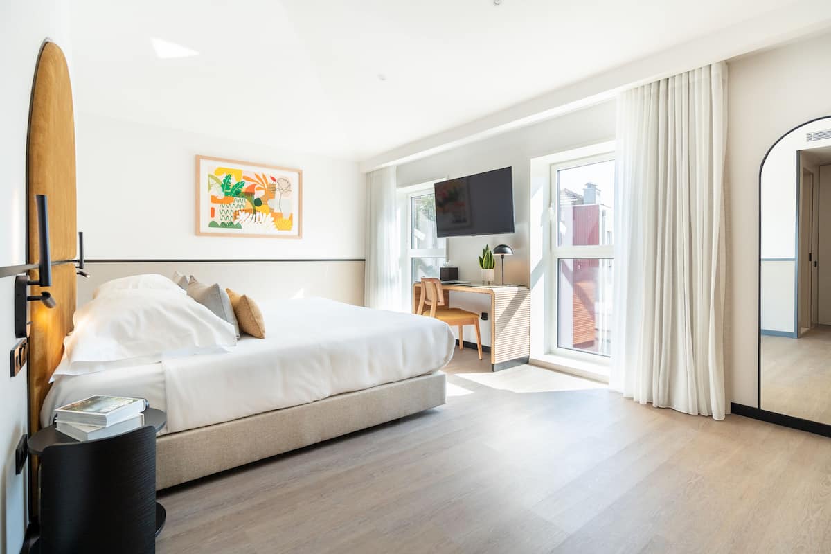 Una habitación de hotel moderna con cama, escritorio y televisión.