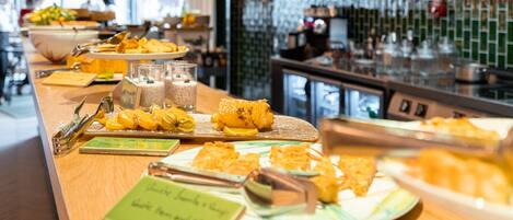 A buffet with various dishes and a coffee machine in the background.