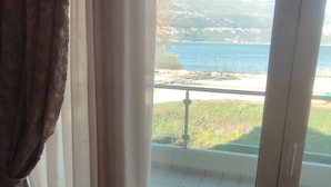 Une chambre avec vue sur un plan d’eau et des collines.