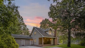A two-story house with a covered front porch, a garage, and a well-maintained lawn. - Harbor View Haven | Waterfront w/ Hot Tub + Dock! (Chestertown)