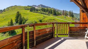 A wooden balcony with a view of a green hillside and mountains. - Ski-in/Ski-out apartment for 6 in Avoriaz with balcony and WiFi (Avoriaz)