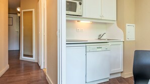A compact kitchen with white cabinets, a microwave, and a dishwasher. - Ski-in/Ski-out apartment for 6 in Avoriaz with balcony and WiFi (Avoriaz)