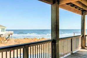 A wooden deck overlooking a beach with a lifeguard tower in the background. - A'Wave From It All - WOW View, Steps to Beach Entrance! (Freeport)