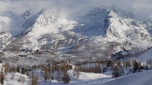 A snow-covered mountain landscape with a ski lift and a small settlement at the base. - Cozy south-facing apartment, 4 people, near funicular (Isola 2000)