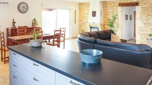 A modern living space with a kitchen area, a dining table, and a seating area with a sofa.