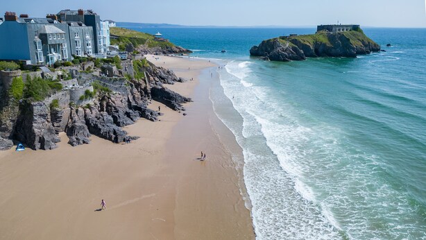 A coastal hotel with a beach view, rocky cliffs, and a lighthouse in the distance. - Croft Court - 1 Bedroom Apartment - Tenby (Tenby)