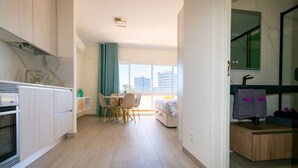 Een modern appartement met keuken, eethoek en slaapkamer.
