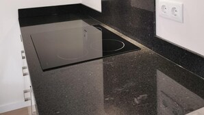 Eine moderne Küche mit schwarzem Arbeitsplatz, integriertem Herd und stilvoller Rückwand.