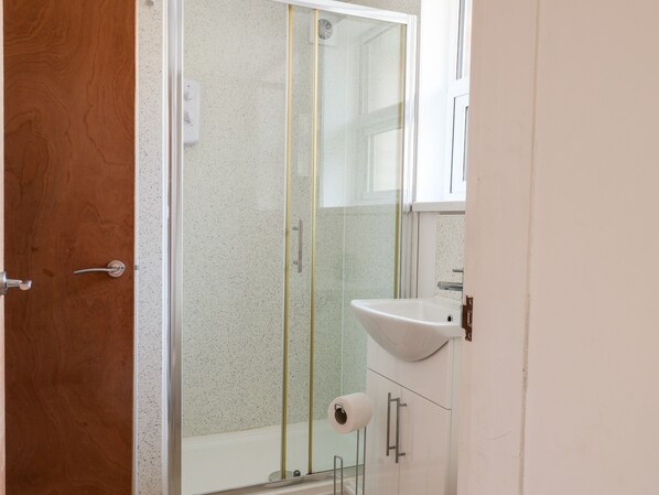 Un baño con ducha, lavamanos e inodoro.