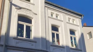 A white building with multiple windows, a date plaque reading "1908", and a small sign indicating "Hall". - 1 Bedroom Apartment in Bonn (Bonn)
