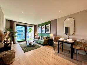 Relax in this stylish living room with a sofa, dining area, and large window offering a view of the outdoors.