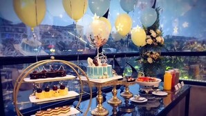 A dessert table with various cakes and pastries, a small Christmas tree, and balloons. - Ondine Oriental International Hotel (Zhenjiang)