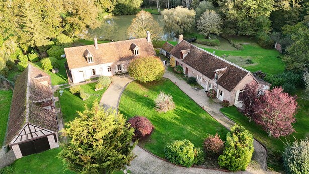 An aerial view of a large estate with multiple buildings, a well-maintained lawn, and a pond. - Treat yourself to a true escape, far from the noise and the everyday routine. (Marcilly-en-Gault)