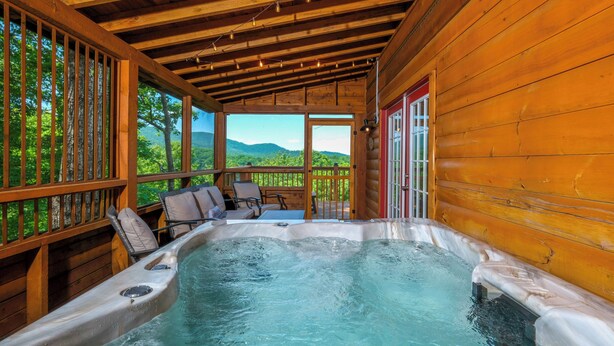 Een hottub in een houten chalet met uitzicht op de bergen.