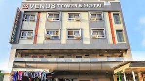 A multi-story building with the sign "Venus Tower & Hotel" indicating it is a hotel.