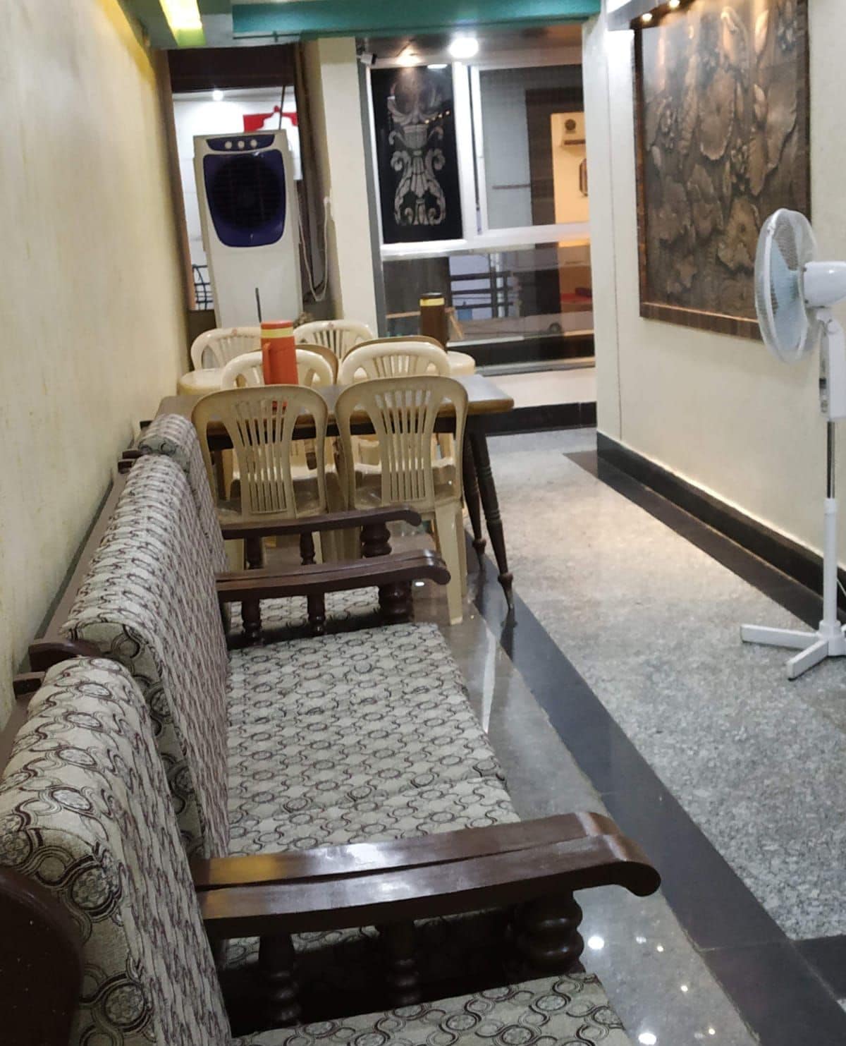 A dining area with a sofa, chairs, and a fan.