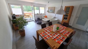Une cuisine moderne avec une table à manger, des chaises et une grande fenêtre.