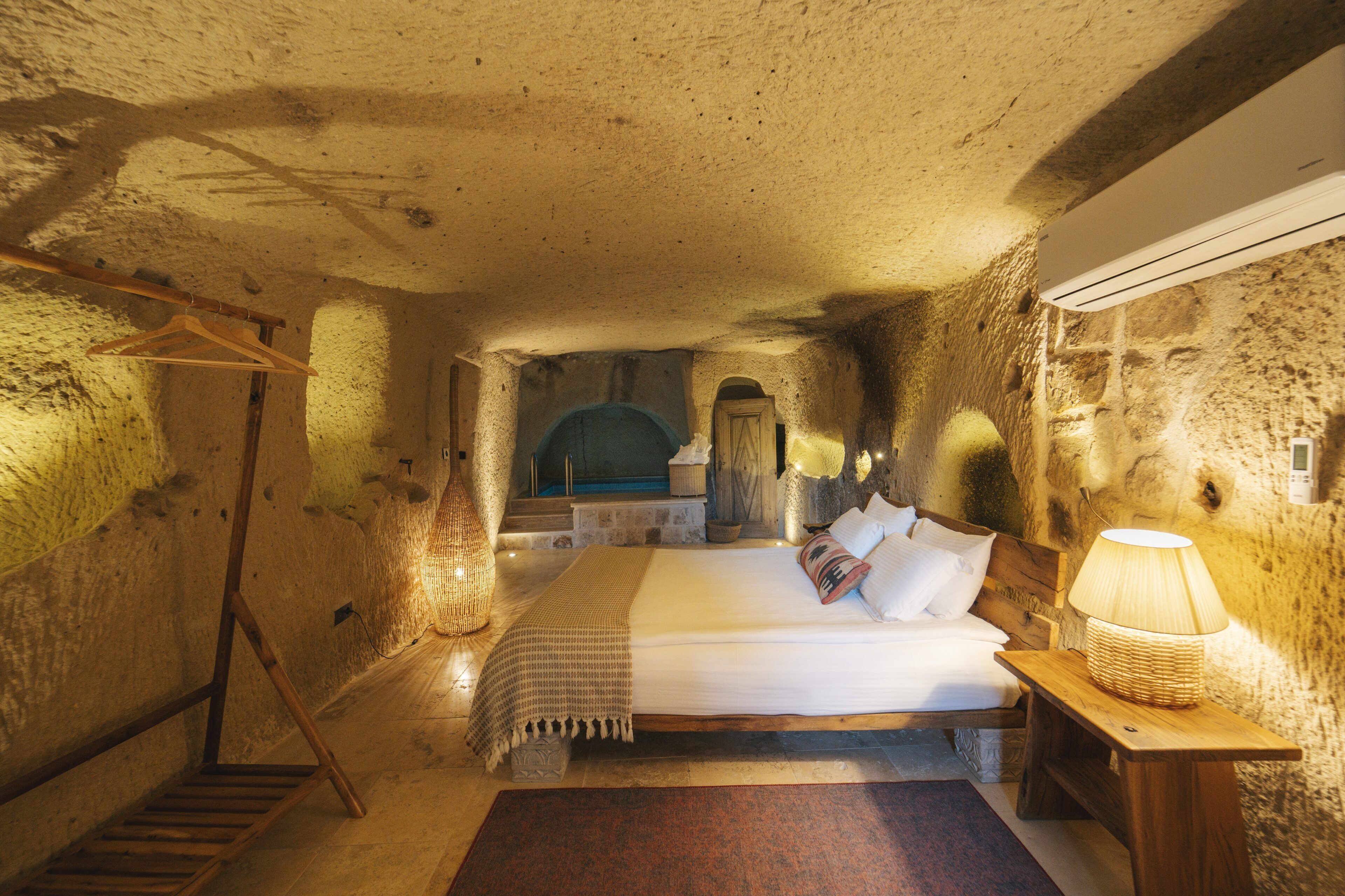Una habitación rústica con una cama, muebles de madera y una pared de piedra.