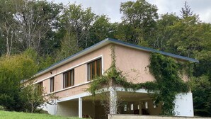 A modern house with a flat roof, large windows, and a covered porch.