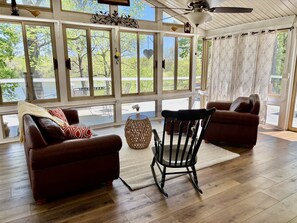 A sunlit room with large windows, a ceiling fan, and a view of a deck. - Grand Lake Estate Luxury Waterfront Retreat (Mount Juliet)