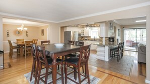 A spacious kitchen with wooden cabinets, a dining area with a large table and chairs, and a living area with a sofa and a coffee table. - Grand Lake Estate Luxury Waterfront Retreat (Mount Juliet)
