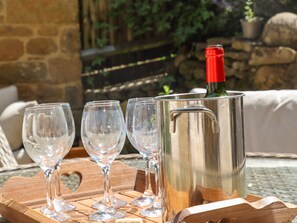 A stainless steel wine cooler with a red cap, four empty wine glasses, and a corkscrew on a wooden tray. - 1 The Lane (Moreton-in-Marsh)