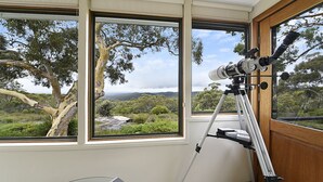 A room with large windows offering a view of a natural landscape, including trees and hills. - Sydney View - 70km from Sydney; 1000km from care! (Woodford)