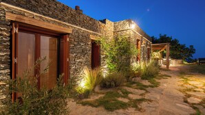 A stone building with wooden doors and a stone pathway.