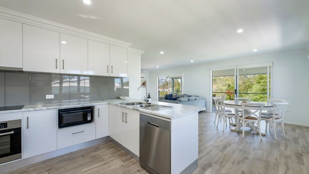 A modern kitchen with white cabinetry, stainless steel appliances, and a central island.