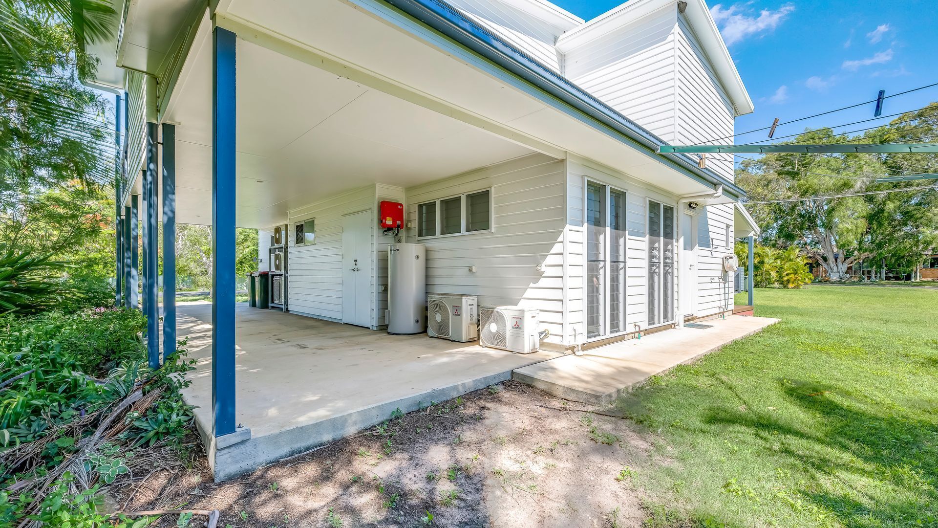 Een huis met een overdekte veranda, een garage en een gazon.