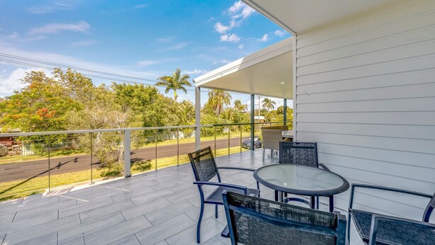 A covered outdoor seating area with a view of a road and trees. - The Cottage - 16 Clarke Street (Bargara)