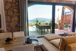 A dining area with a table, chairs, and a view of the outdoors. - Bodrum Akkartal Panoramic Konaklama Tesisi   (Bodrum)